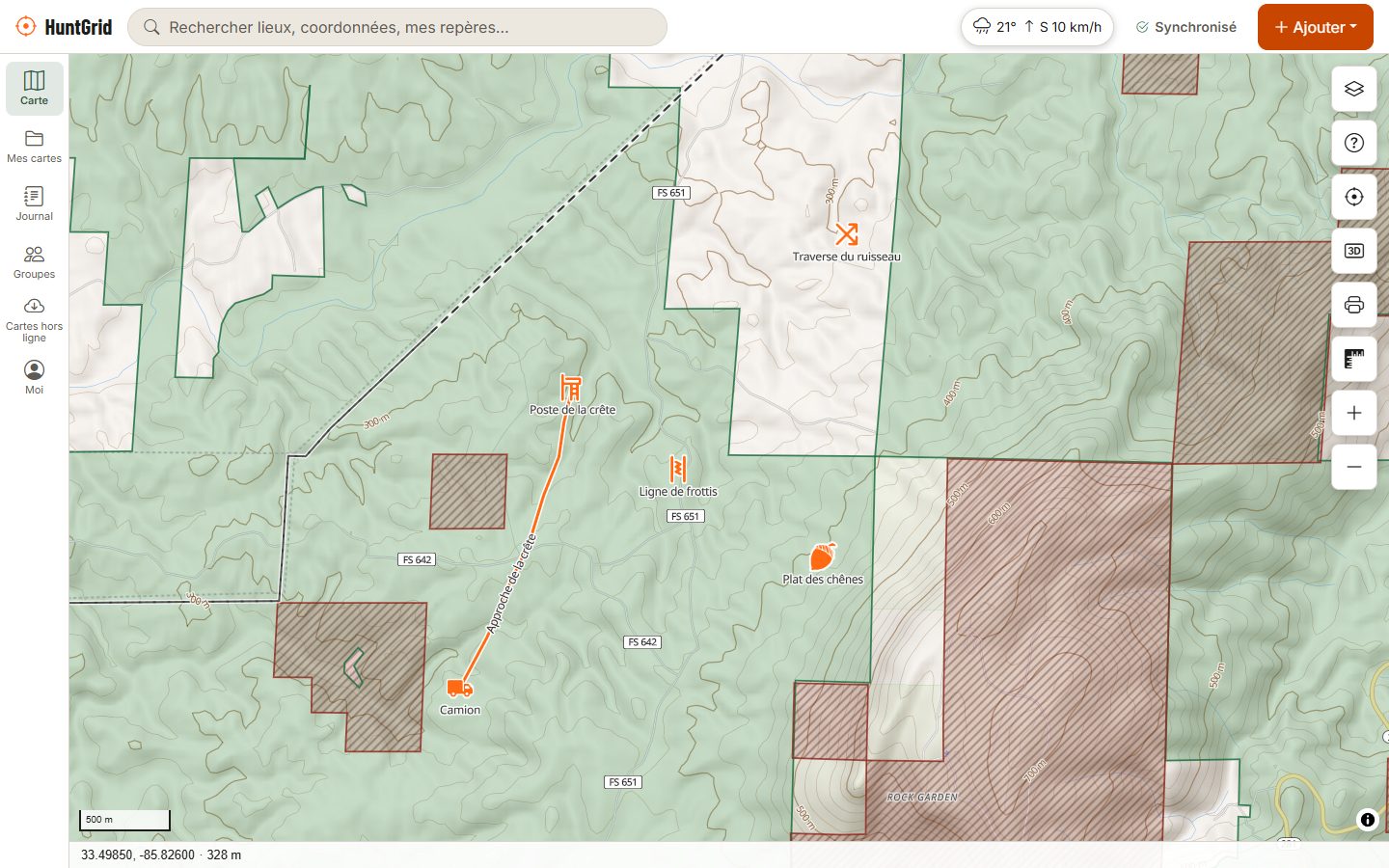 HuntGrid sur un ordinateur : une carte topo de la forêt nationale Talladega, les terres publiques en vert, les secteurs fermés hachurés, et le poste, la ligne de frottis et la trace d'approche d'un chasseur.